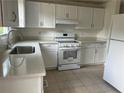 Bright kitchen featuring white cabinetry, modern appliances, and stone countertops at 1185 Jocelyn Ct, Stone Mountain, GA 30088