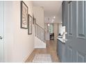 View of the home's entryway displaying light wood floors and a modern staircase with iron spindles at 290 Abbotts Crossing Cir, Conyers, GA 30094