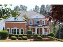 Elegant brick home featuring a charming front porch and well-maintained landscaping for a classic look at 5029 Preservation Pointe, Kennesaw, GA 30152