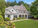Charming two-story home boasts beautiful landscaping, a brick facade and a welcoming front porch at 295 River Laurel Way, Woodstock, GA 30188
