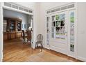 Bright foyer with natural light from a multi-paneled glass door, hardwood floors, and an adjacent dining room at 295 River Laurel Way, Woodstock, GA 30188