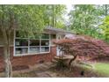 Close up of red brick home featuring mature landscaping, including a red Japanese maple tree at 4052 Shawnee Ne Ln, Brookhaven, GA 30319