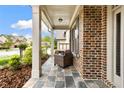 Charming covered front porch with stone tiles and a cozy outdoor seating area at 4779 Moon Hollow Ct, Buford, GA 30519