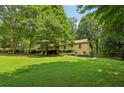 Well-maintained lawn and mature trees surrounding the home in a picturesque yard at 211 Black Kettle Ln, Johns Creek, GA 30022