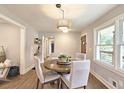 Cozy dining room featuring a round table, stylish chairs, a modern light fixture, and hardwood floors at 217 Penelope Nw Dr, Atlanta, GA 30314