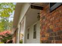 Close-up of the home's entrance with brickwork, white columns and a hanging lantern at 4444 Bending River Sw Trl, Lilburn, GA 30047