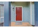 Close-up of the red front door featuring a stylish light fixture and light blue shingle siding at 7629 Park Ln, Jonesboro, GA 30236