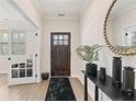 Inviting foyer with light wood floors, black accents, a decorative mirror and french doors at , Powder Springs, GA 30127