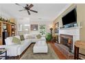 Bright living room featuring a cozy fireplace, plush sectional sofa, and a ceiling fan at 2229 Polder Way, Austell, GA 30168