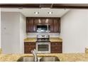 Well-lit kitchen featuring stainless steel appliances, granite countertops and dark wood cabinets at 1130 Piedmont Ne Ave # 410, Atlanta, GA 30309