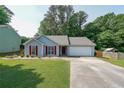 Traditional home boasts a manicured lawn, long driveway, attached garage and charming red shutters, creating a welcoming curb appeal at 2889 Estuary Dr, Acworth, GA 30101