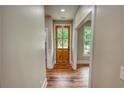 Warm and welcoming foyer featuring a wood-look floor and a natural wood front door with glass panels at 25 Oakbrook Ln, Covington, GA 30016