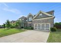 A charming two-story home with a gray brick exterior, well-maintained lawn, and a two car garage at 3399 In Bloom Way, Auburn, GA 30011