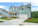 Beautiful two-story home with a front porch, lush green lawn, and driveway leading to the two-car garage at 1606 Chancery Ln, Lithia Springs, GA 30122