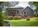 The home's backyard has a sunroom, wooden deck, verdant lawn, and landscape garden at 2646 Kinnett Sw Dr, Lilburn, GA 30047