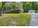 A brick home with a carport and a detached two-car garage, set in a lush green lawn at 509 Woodland Ln, Lawrenceville, GA 30043