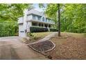 Side view of a two story home with a long driveway and lush surroundings at 569 Hale Mountain Ct, Hiram, GA 30141