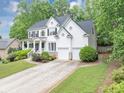 Charming two-story traditional home featuring a two-car garage, and a beautifully landscaped front yard at 115 Blue Ridge Trl, Powder Springs, GA 30127