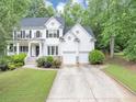 Charming two-story traditional home featuring a two-car garage, and a beautifully landscaped front yard at 115 Blue Ridge Trl, Powder Springs, GA 30127