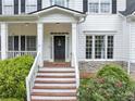 Welcoming front entrance featuring a covered porch with classic columns and well manicured landscaping at 115 Blue Ridge Trl, Powder Springs, GA 30127