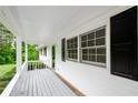 Cozy covered porch with freshly painted railings, black shutters, and a brick foundation at 2923 Bicentennial Dr, Stone Mountain, GA 30087