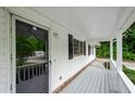 Inviting covered front porch with a storm door, offering a glimpse of the lush greenery outside at 2923 Bicentennial Dr, Stone Mountain, GA 30087