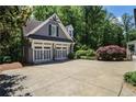 A two-car garage with matching trim sits surrounded by lush greenery and plenty of parking space at 4586 Smoke Rise Ln, Marietta, GA 30062