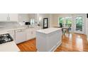 Pristine white kitchen with quartz countertops, an island, and direct access to the outdoor deck at 2185 Arbor Chase, Cumming, GA 30041