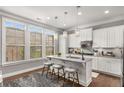Bright kitchen features white cabinetry, quartz countertops, stainless appliances and a breakfast bar at 3592 Parkhaven Pl, Brookhaven, GA 30319