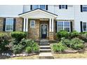Charming entrance with stone facade, blossoming shrubs, and a walkway leading to the front door at 3811 Holliwell Pass, Cumming, GA 30040