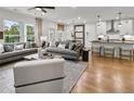 Open-concept living room and kitchen with hardwood floors, modern lighting, and stylish furnishings at 5230 Hyde Rd, Cumming, GA 30040