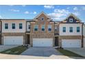 Attractive townhome exterior with a brick facade, light-colored siding, and individual single-car garages at 867 Eagle Avenue, Riverdale, GA 30296