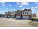 Townhome community featuring brick and siding exteriors, individual garages, and manicured green spaces at 867 Eagle Avenue, Riverdale, GA 30296