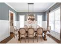 Formal dining room with a large table, stylish lighting, and wainscoting at 3042 Jefferson St, Atlanta, GA 30341