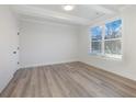 Sun-drenched bedroom showcasing neutral walls, wood flooring, and large windows at 4055 Hosch Retreat Dr, Buford, GA 30519