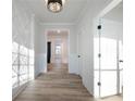 Bright hallway featuring beautiful molding, modern lighting, and attractive flooring at 4055 Hosch Retreat Dr, Buford, GA 30519