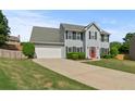 This property showcases a spacious driveway and a neatly kept front lawn at 406 Mount Vernon Ct, Woodstock, GA 30189