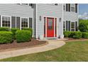 Close-up of home's entrance, featuring a vibrant red door and manicured bushes at 406 Mount Vernon Ct, Woodstock, GA 30189