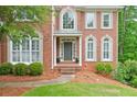 Detailed view of the home's entrance, showcasing the brick facade and manicured landscaping at 305 High Branch Way, Roswell, GA 30075