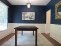 Elegant dining room featuring dark blue walls, white wainscoting, and a refined table setting for sophisticated meals at 4832 Batiste Nw Ln, Acworth, GA 30101