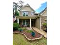 Inviting home exterior with stone accents, well-maintained landscaping, and a cozy front porch at 4832 Batiste Nw Ln, Acworth, GA 30101