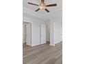 Spacious bedroom with wood flooring, a ceiling fan and multiple closets and doorways at 853 Pensive Run, Dacula, GA 30019