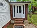 Inviting front entryway with decorative glass door, complemented by brick accents and manicured landscaping at 1720 Valley Ln, Cumming, GA 30040