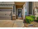 Welcoming front entrance featuring a stylish door, brick accents, and lush green landscaping at 255 Skipjack Ct, Covington, GA 30016