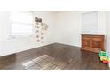 Sunlit bedroom with hardwood floors, neutral walls, and a charming wood dresser at 2576 Flat Shoals Dr, Decatur, GA 30034