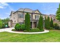 Side view of beautiful home with stone and brick, complemented by a lush green lawn and landscaping at 3810 Sweat Creek Run, Marietta, GA 30062