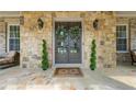 Inviting stone front porch with double doors, decorative wreaths, and stylish outdoor seating at 3810 Sweat Creek Run, Marietta, GA 30062
