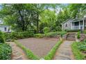 Landscaped backyard featuring a detached guesthouse with stone steps, a stone wall and a gravel area at 25 Standish Nw Ave, Atlanta, GA 30309
