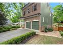 Side view of brick and green-paneled house with a two-car garage, brick accents and landscaped bushes at 3668 Spring St, Chamblee, GA 30341