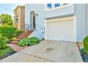 Close-up of the townhome's entry featuring a front porch, garage, and well-maintained landscape at 3688 E Bay St, Duluth, GA 30096